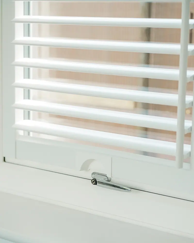 Hand opening a white shutter